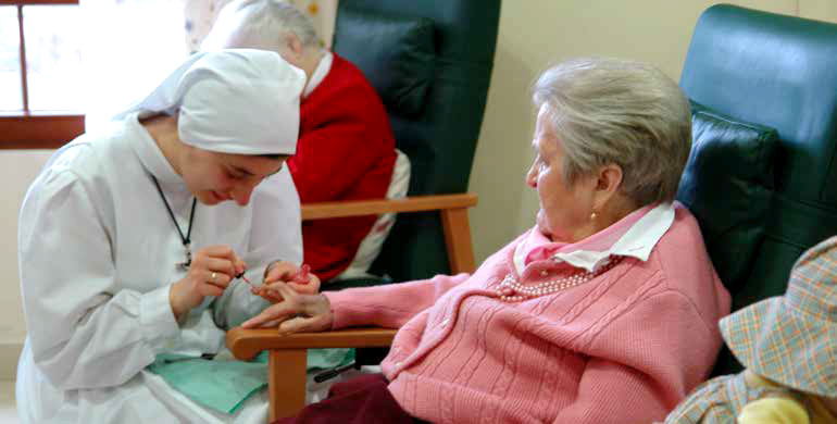 Hna. Lucía pintando las uñas a una abuelita